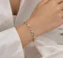 Gold and silver-tone bracelet with white stone-set teardrop links.