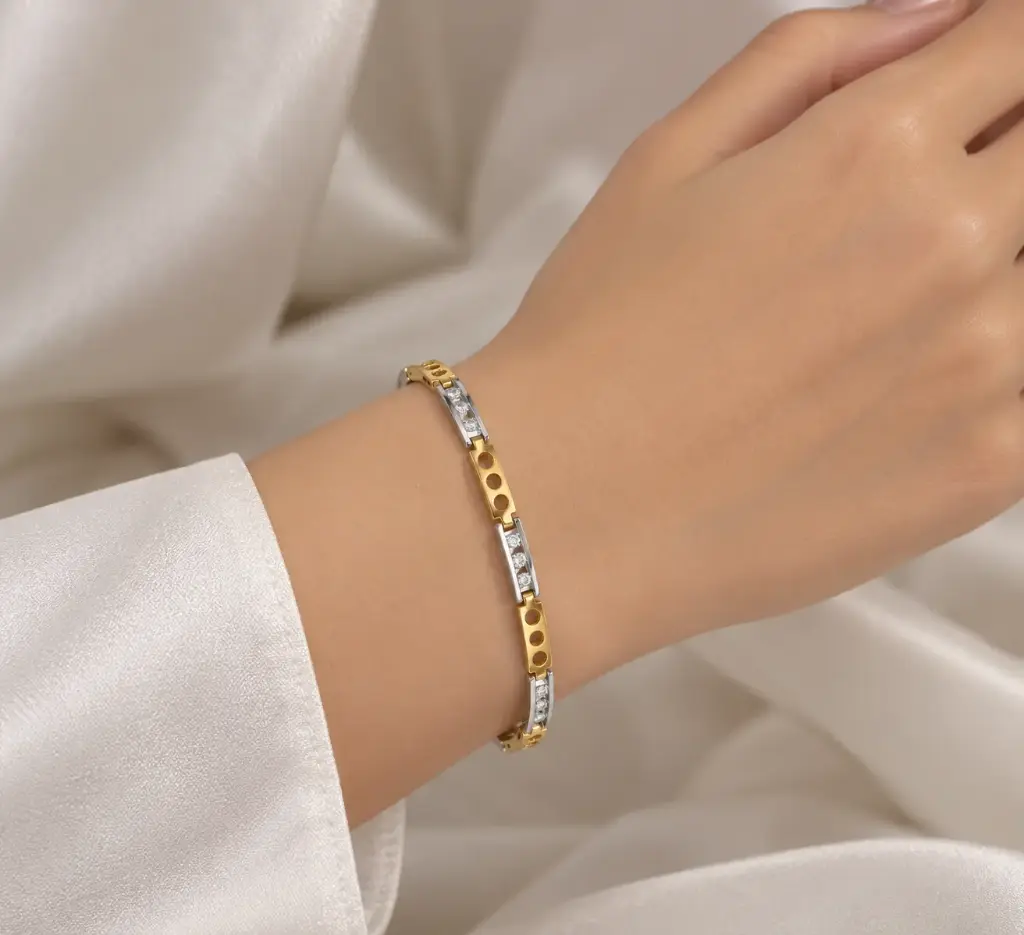  Gold and silver-tone bracelet with rectangular links and white stones.