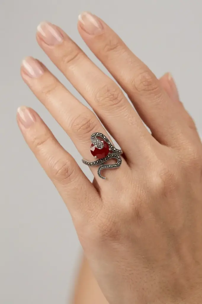 An ornate snake-design ring featuring a round red stone.