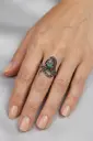 An ornate snake-design ring featuring a round multicolored stone in shades of green and purple.