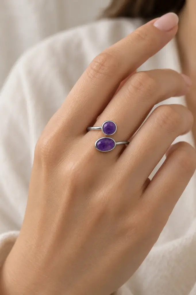 A minimalist open ring featuring two purple stones, one round and one oval.
