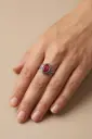 An ornate ring featuring an oval red stone