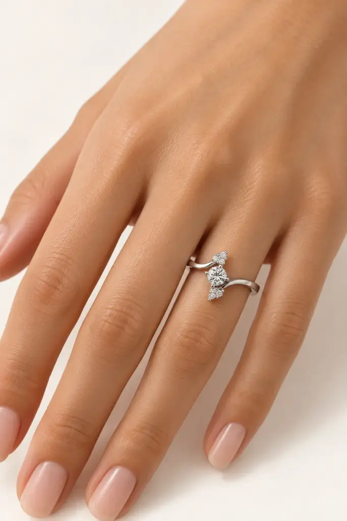 A flowing silver ring featuring a clear center stone and sparkling accents.