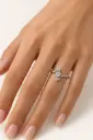 A flowing silver ring featuring a clear center stone and sparkling accents.