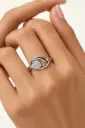 A flowing silver ring featuring an oval cluster of sparkling stones