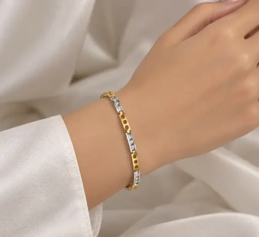  Gold and silver-tone bracelet with rectangular links and white stones.